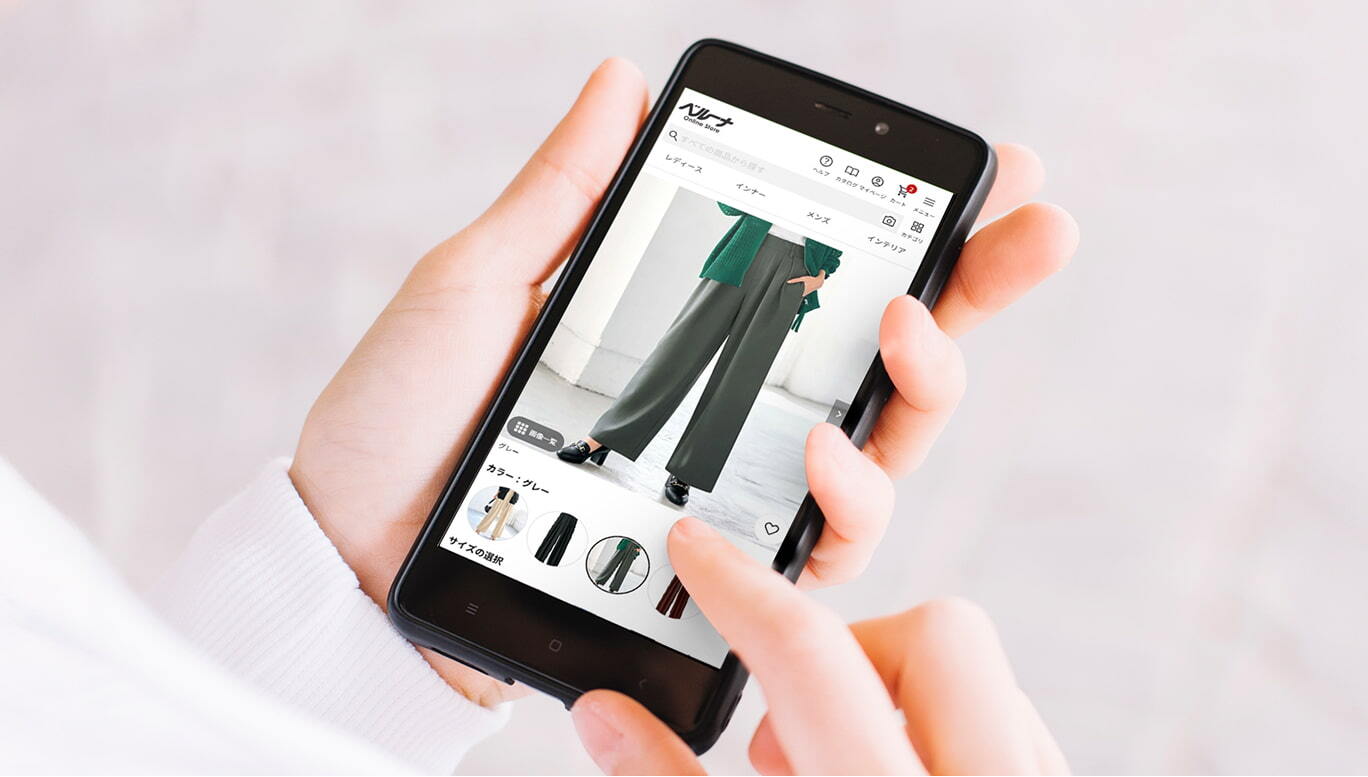 スマートフォンに表示されたECサイトと画面をタッチする女性の手