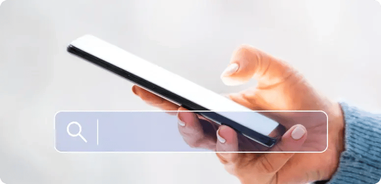 スマートフォンを片手に検索する人の手