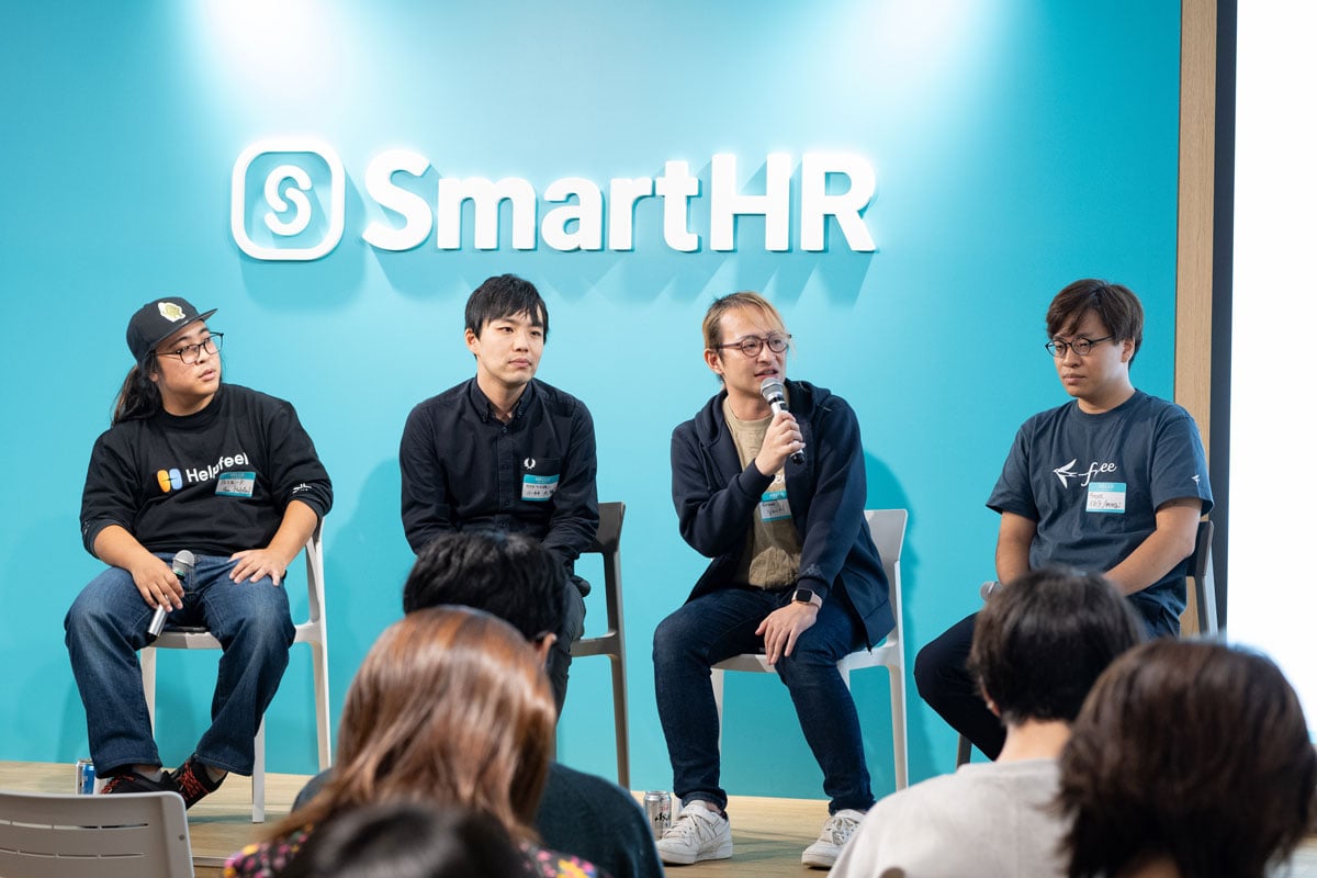 壇上で山本氏がマイク片手に話している