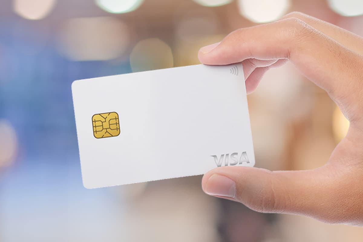手に持たれたライフカード発行の白色のVISAチップ付きクレジットカード