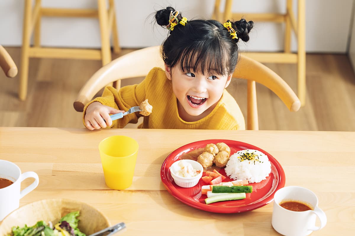 食事を前に笑顔を見せる子ども　Oxxx提供の冷凍幼児宅配サービスモグモのイメージ画像