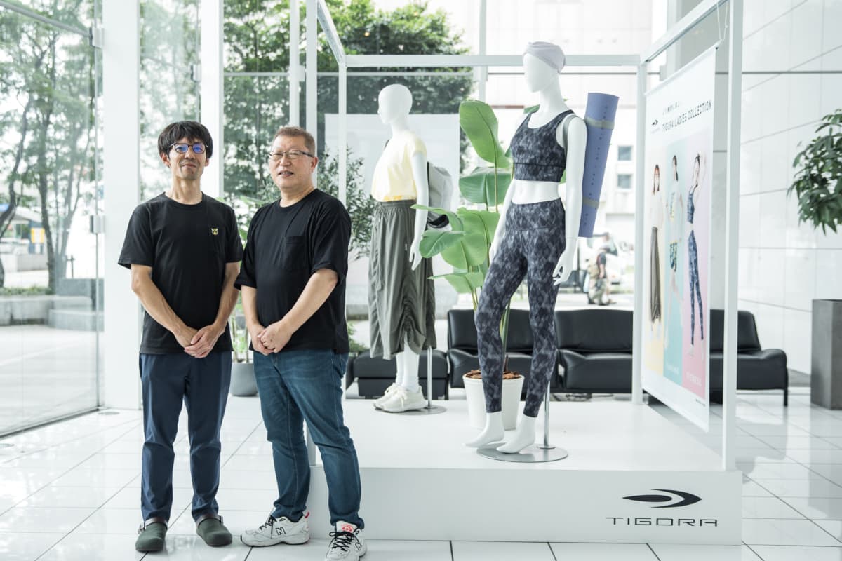 自社が手がけるスポーツ用品の前に立つインタビューイーのお二人