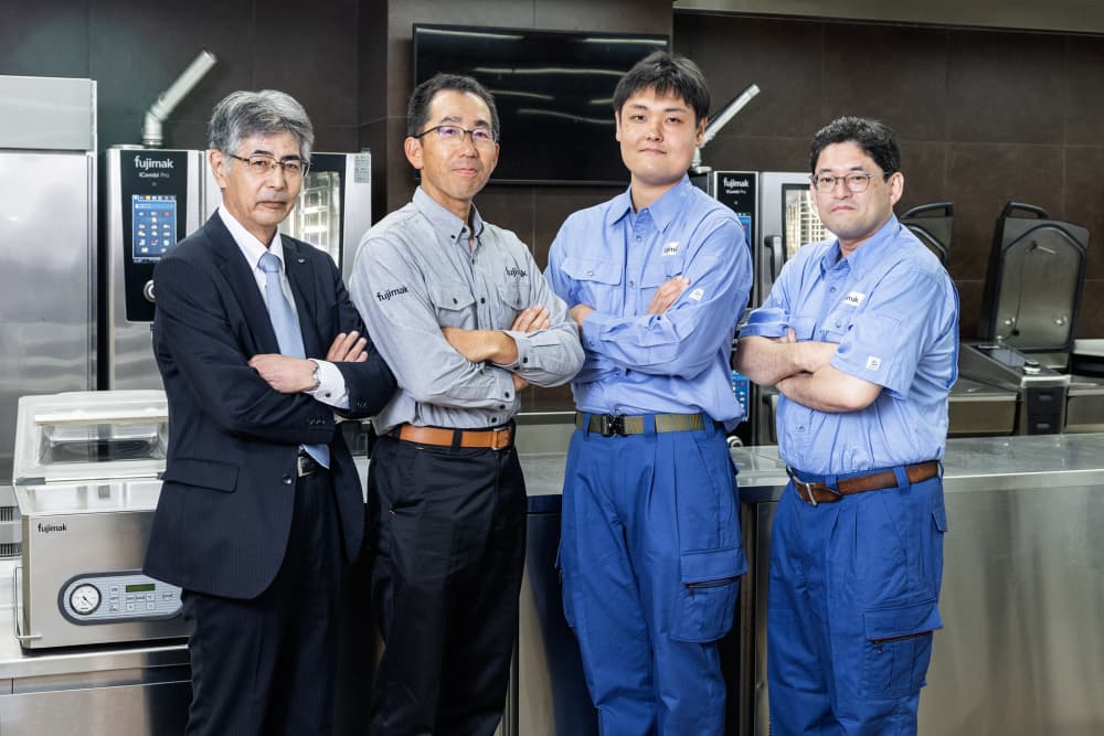 フジマック インタビューイメージ画像　4名の男性が腕を組んで立っている