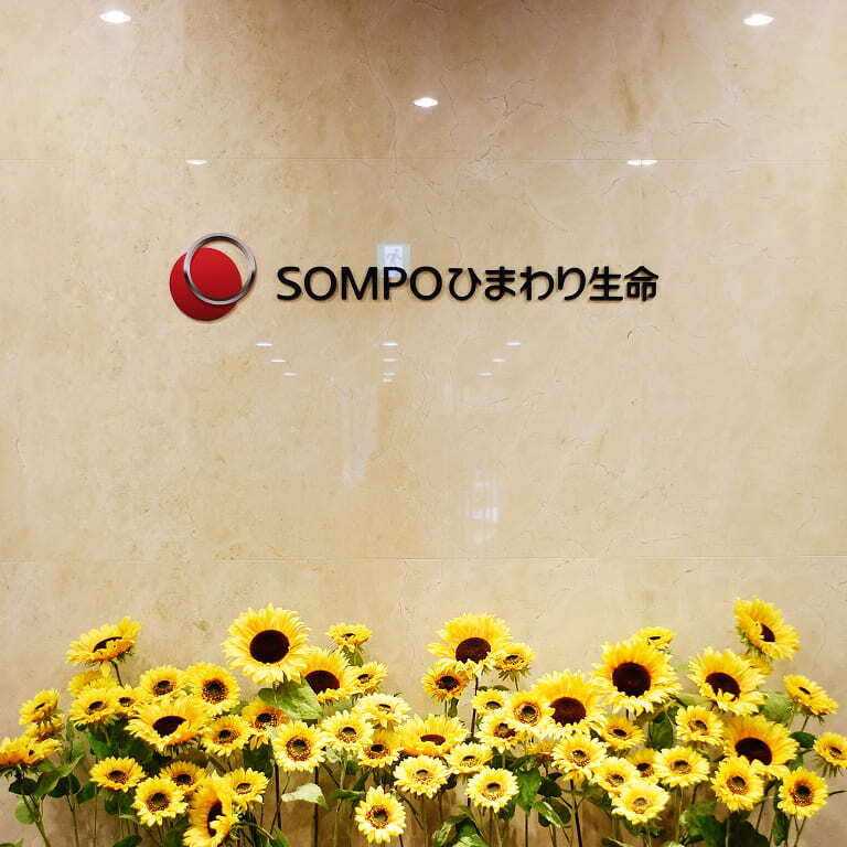 SOMPOひまわり生命のロゴの下にたくさんのひまわりが並んでいる