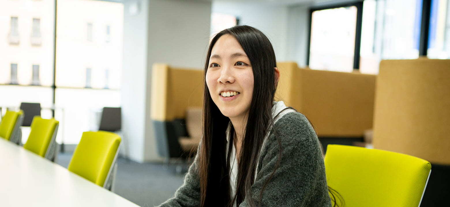 明るいオフィスで笑顔を見せる女性