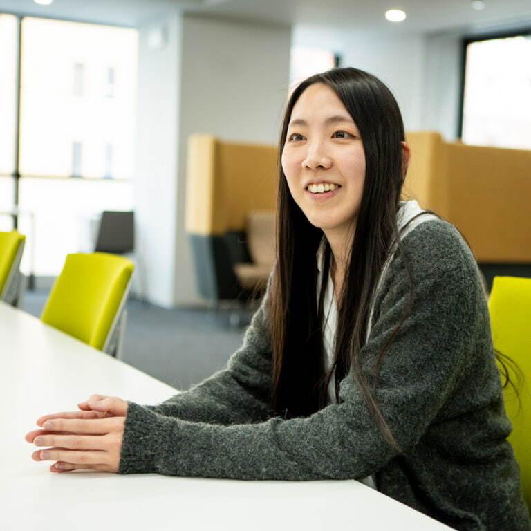 明るいオフィスで笑顔を見せる女性