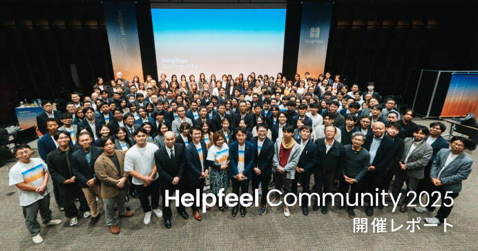 Helpfeel Community 2025 開催レポートのアイキャッチ画像。ステージを背に、非常に多くの参加者が集まった大規模な集合写真。