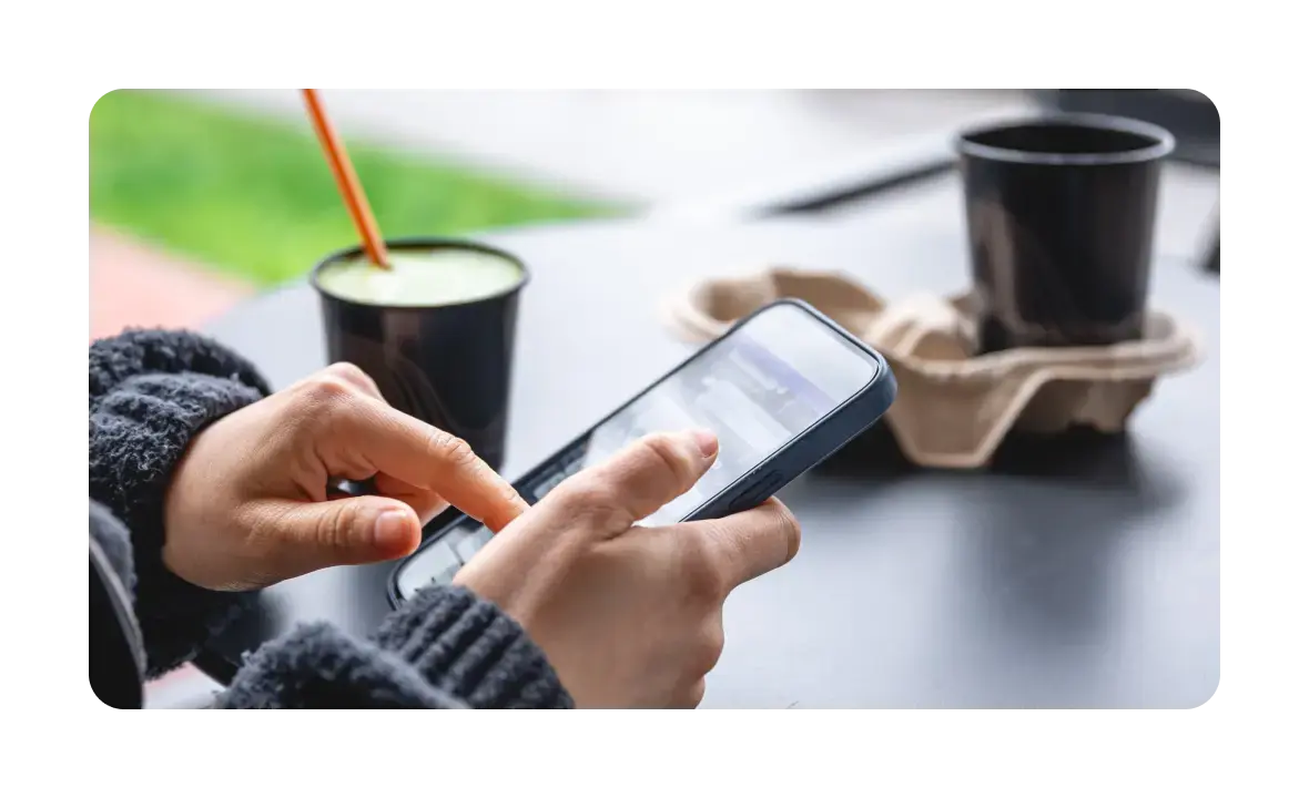テーブルの上でスマートフォンを操作する人物