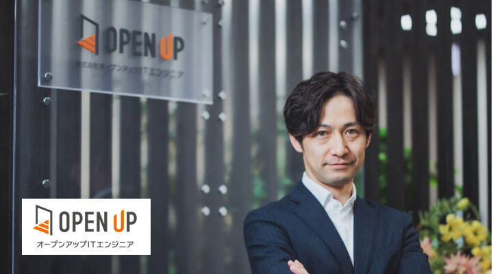 株式会社オープンアップITエンジニアのロゴと、スーツ姿で腕を組む男性社員のイメージ画像